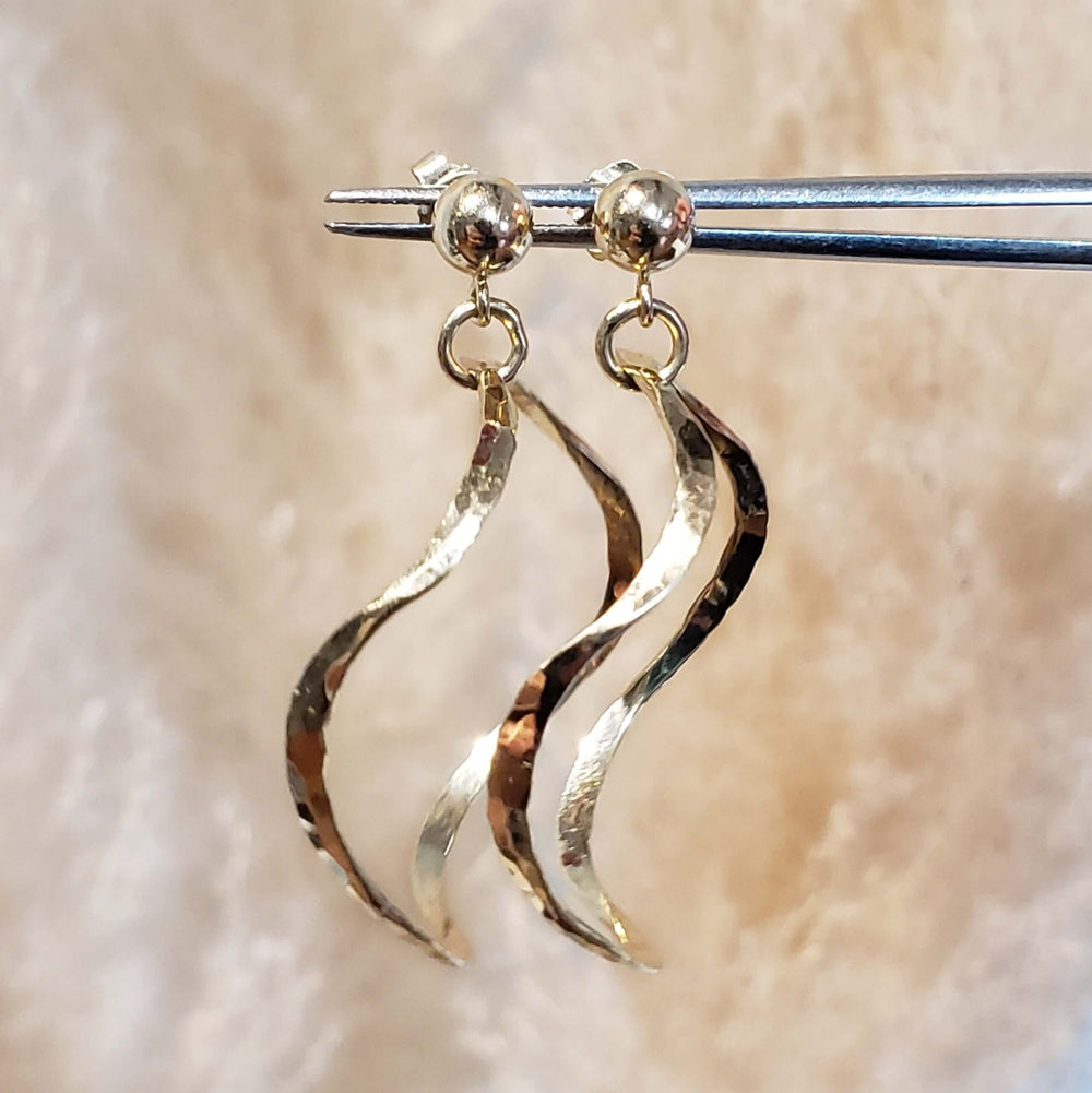 Close-up of vintage squiggle hoop earrings in hammered 14kt yellow gold on display