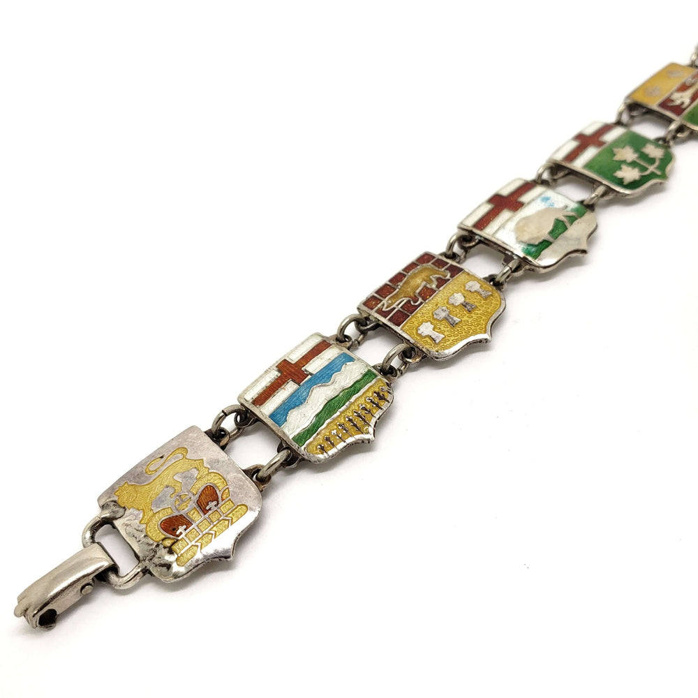 Close-up of vintage sterling silver bracelet featuring enamel provincial crests