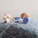 Close-up of 14kt gold tanzanite stud earrings with four-claw setting on a stone