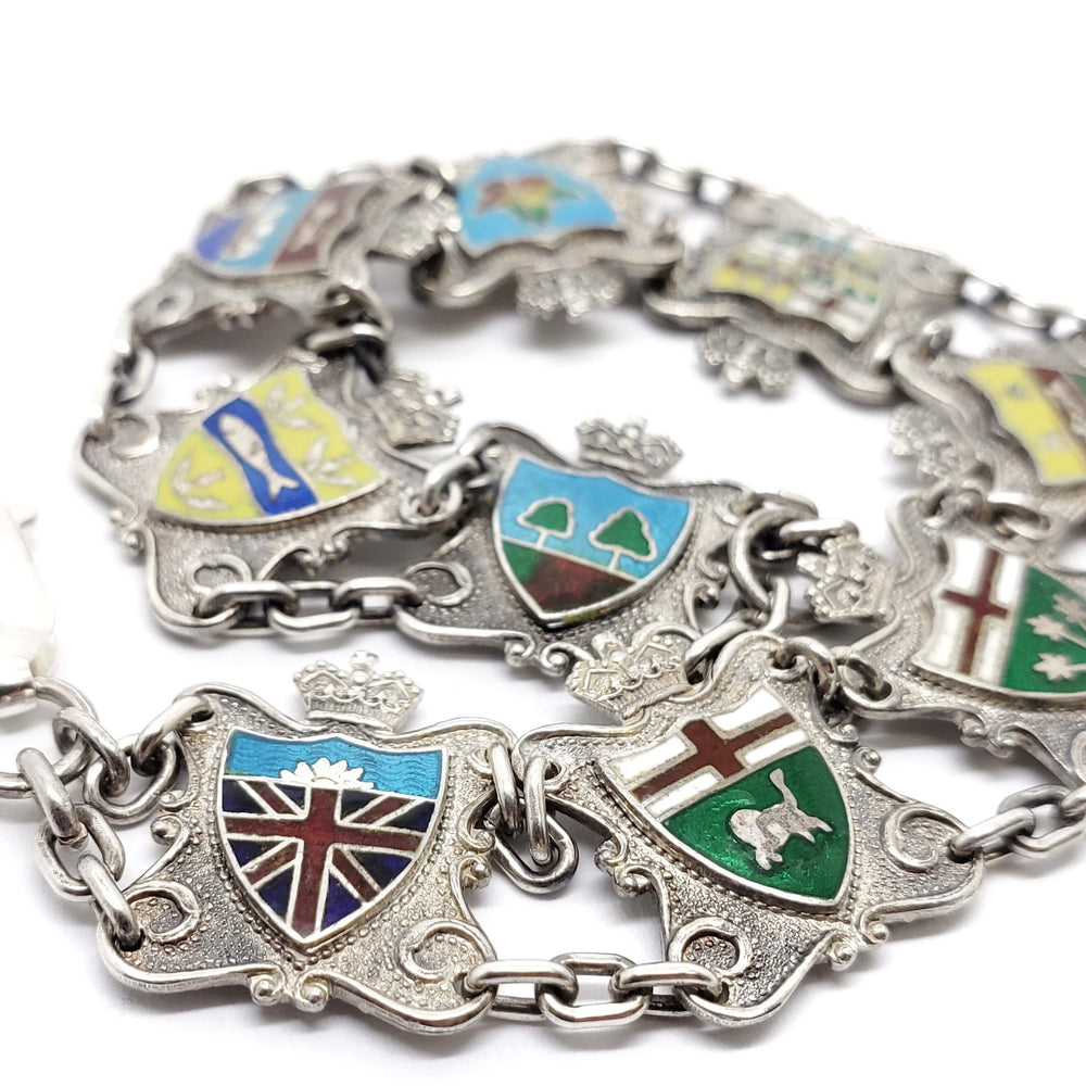 Close-up of vintage silver bracelet with colourful enamel Canadian crests
