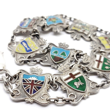 Close-up of vintage silver bracelet with colourful enamel Canadian crests