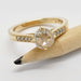 Close-up of yellow gold engagement ring with round rose cut lab diamond and accent stones