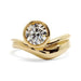 Curvy 14kt yellow gold engagement ring with bezel-set round lab diamond, front view