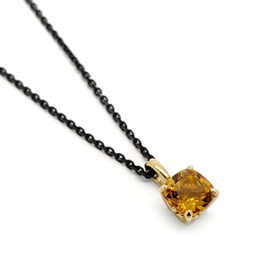 Cushion cut citrine pendant in 14kt yellow gold on black chain, close-up