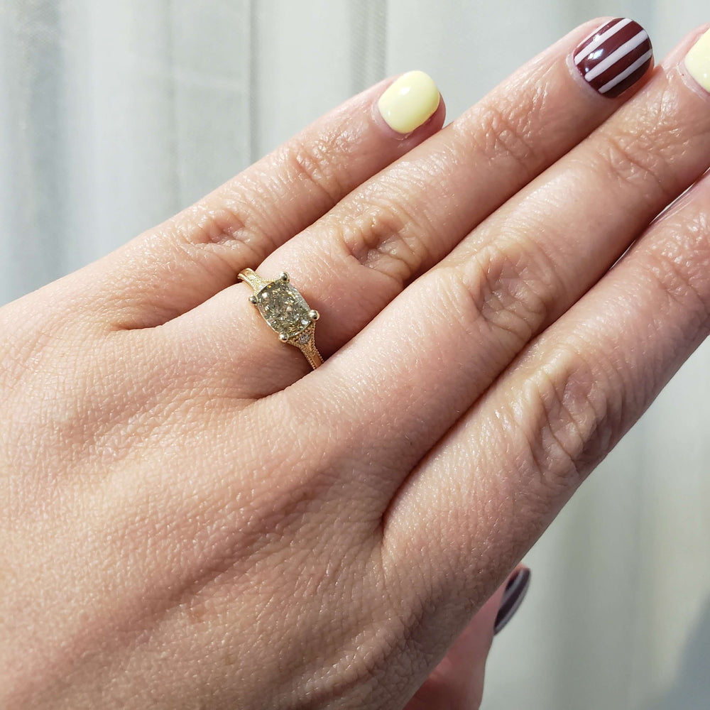 Cushion cut lab diamond engagement ring in yellow gold shown on hand