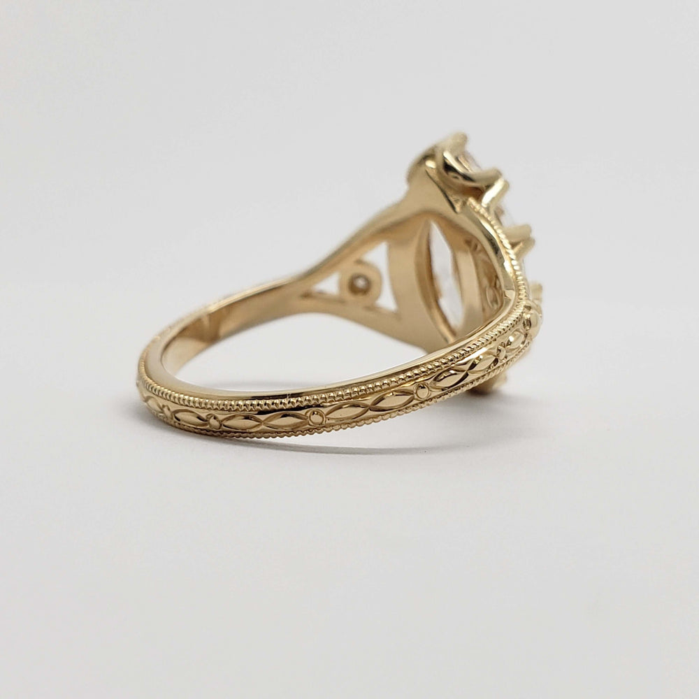 Detailed engraving on 14kt yellow gold band of marquise lab diamond engagement ring