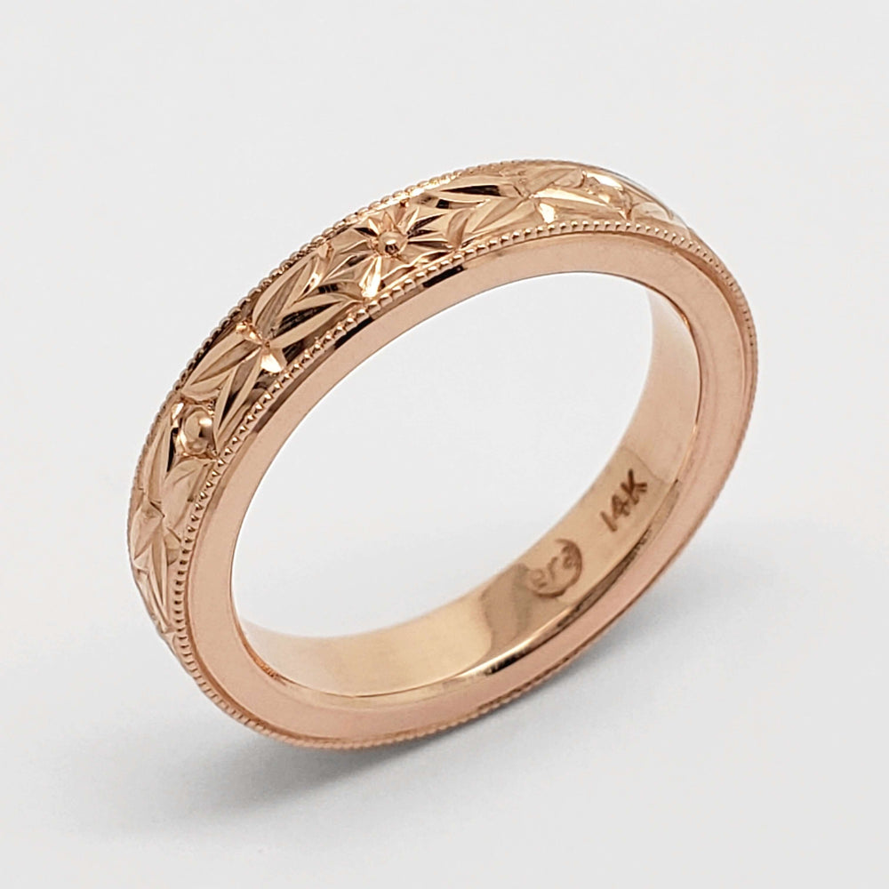 Detailed view of 14kt rose gold floral engraved wedding ring with millgrain edges