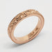 Detailed view of 14kt rose gold floral engraved wedding ring with millgrain edges