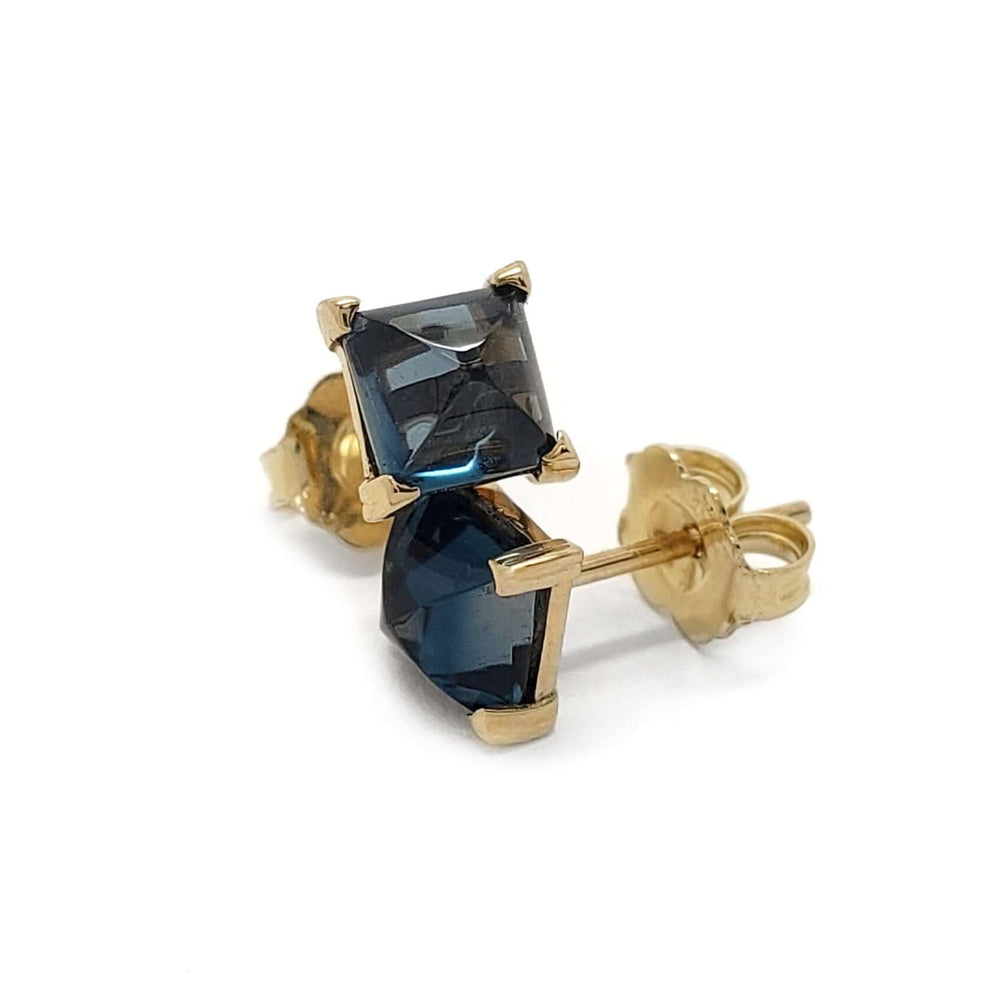 Close-up of 14kt yellow gold stud earring with square cabochon London blue topaz