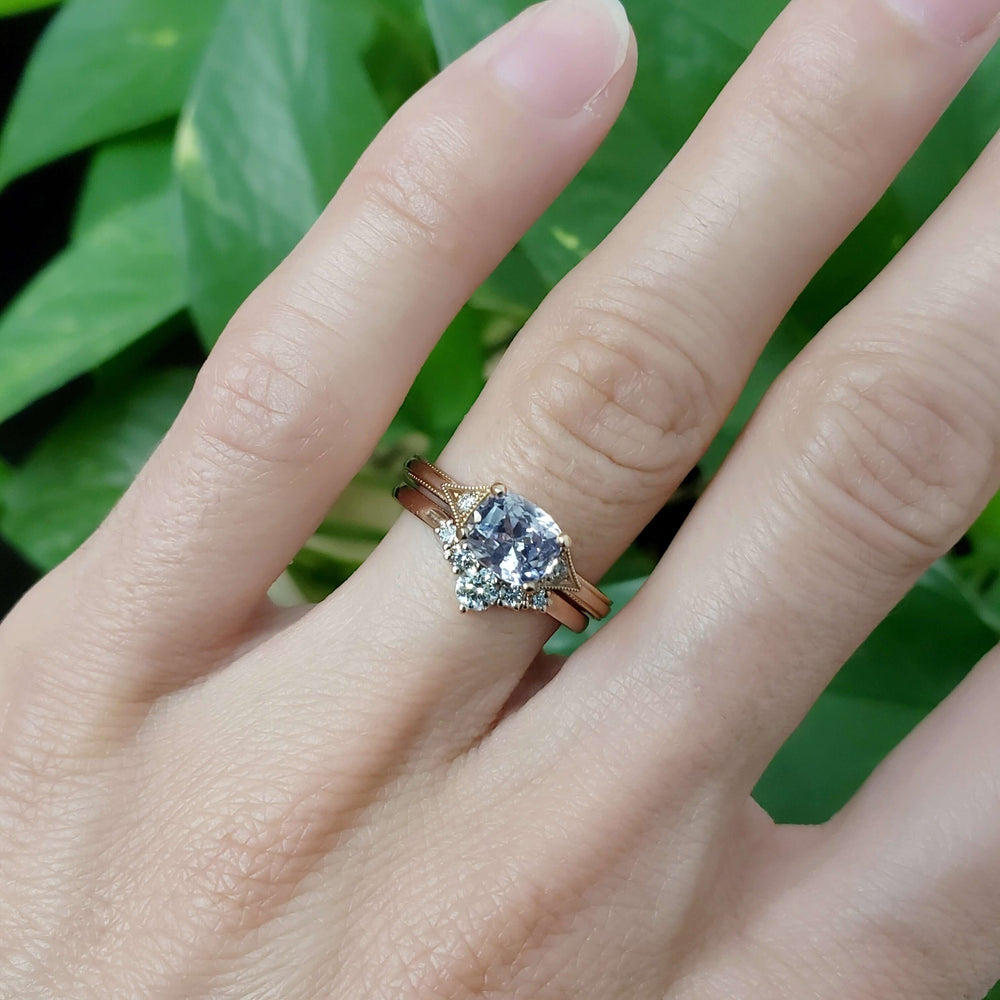 Chevron diamond wedding ring stacked with sapphire engagement ring on hand