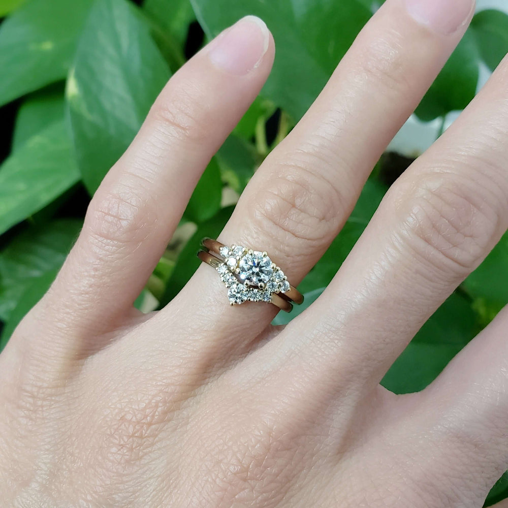 Chevron diamond wedding ring stacked with solitaire engagement ring on hand