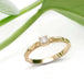 Diamond engagement ring in 14kt yellow gold with leaf motif, shown with green leaves