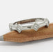 14kt white gold diamond millgrain wedding band resting on a pencil