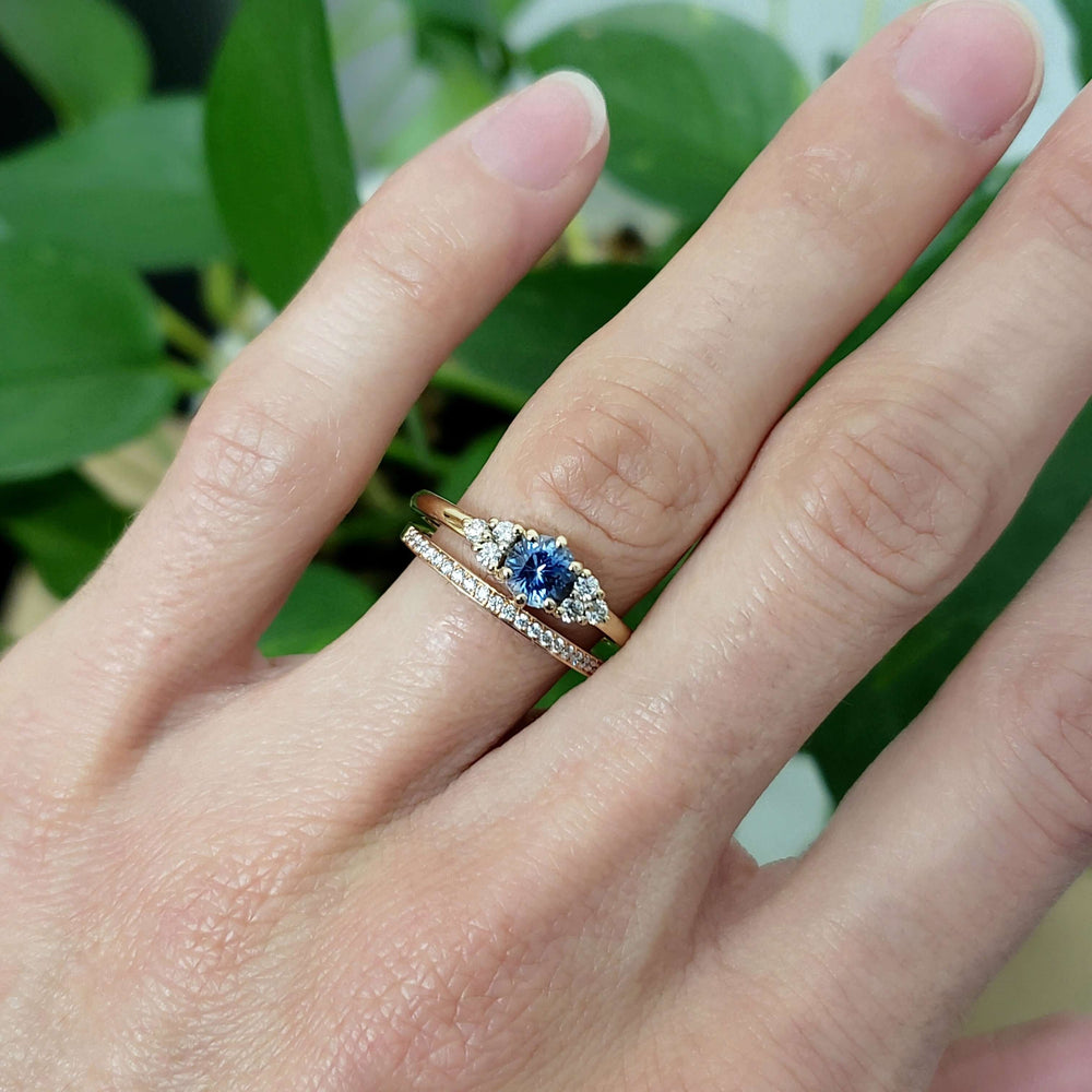 Yellow gold diamond wedding band stacked with a blue sapphire and diamond ring