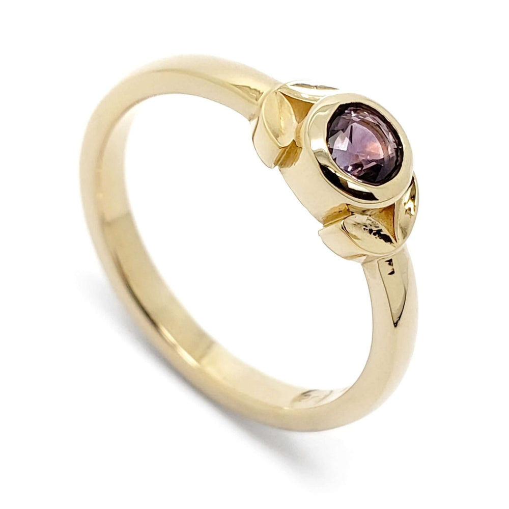 14kt yellow gold engagement ring with bezel-set purple Montana sapphire and leaf detail