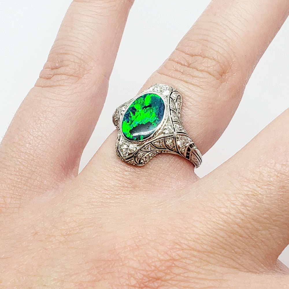 Edwardian platinum opal and diamond ring shown on hand, side view