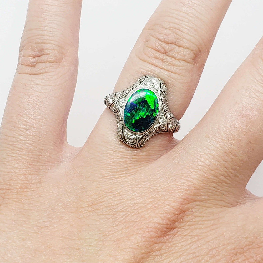 Edwardian platinum opal and diamond ring shown on hand, top view