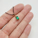 Emerald and diamond pendant in 14kt yellow gold shown on hand for scale