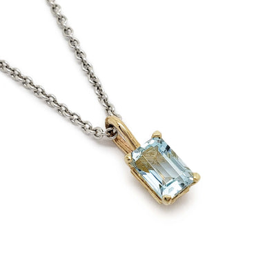 Emerald cut aquamarine pendant in 10kt yellow gold on a silver chain, close-up view