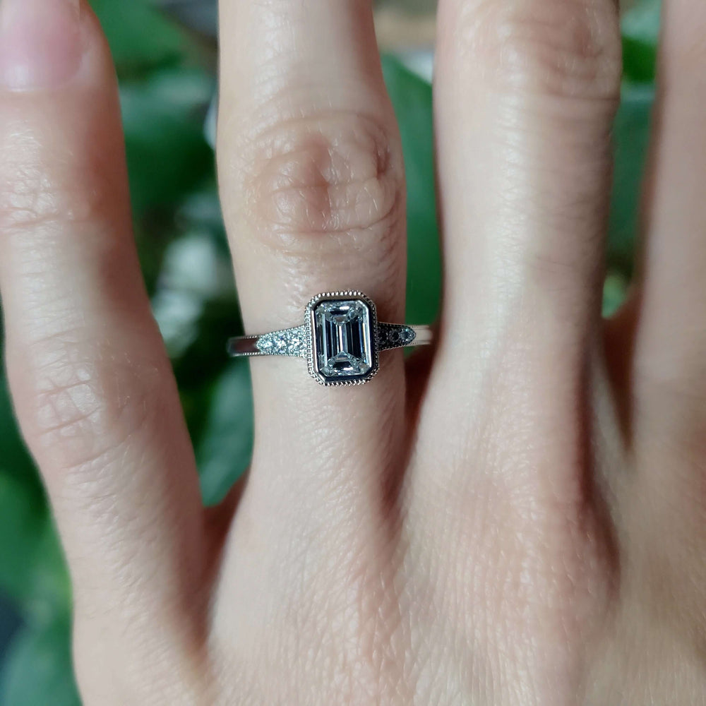 Emerald cut lab diamond engagement ring in white gold, worn on hand
