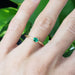 Emerald engagement ring in yellow gold shown on a hand