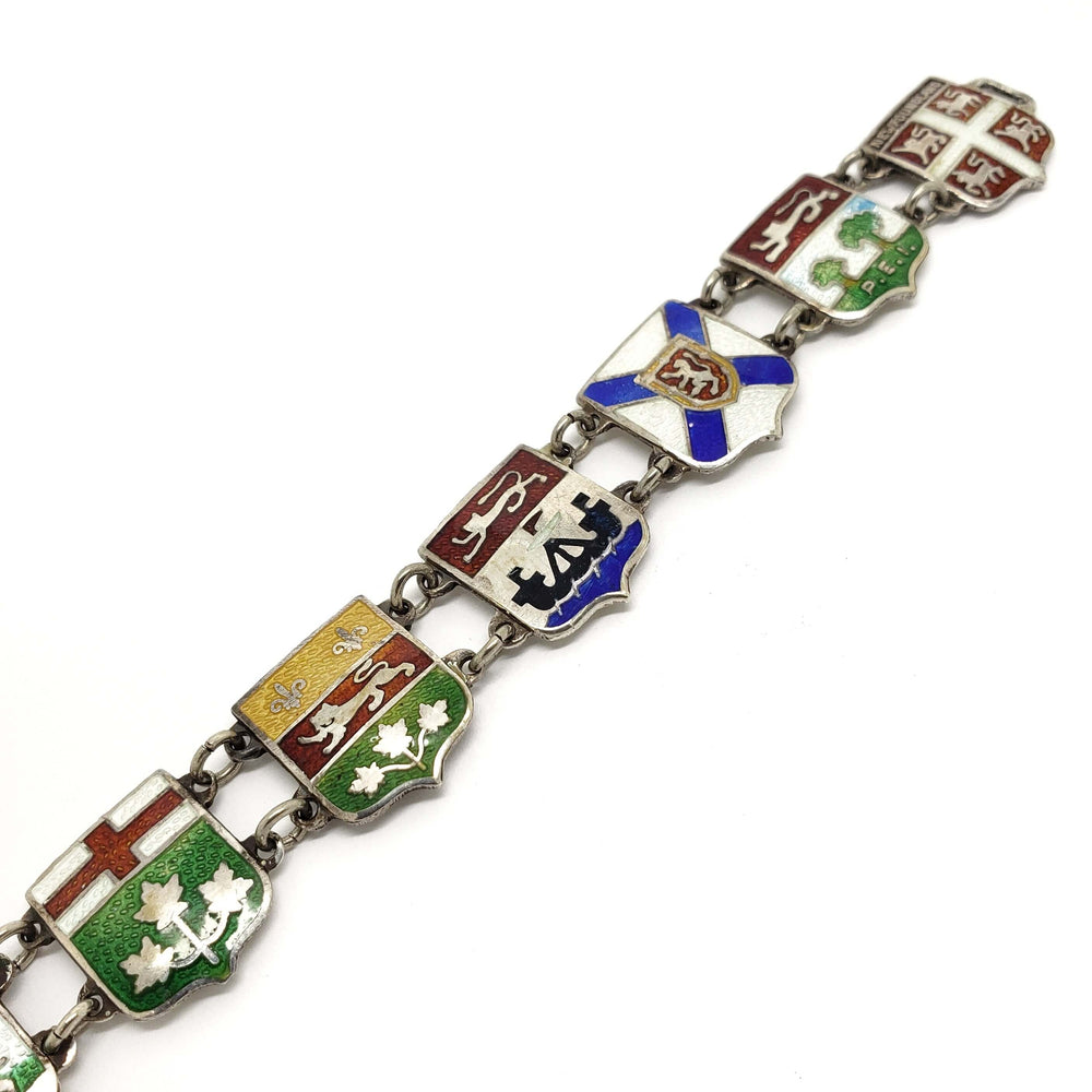 Detailed view of enamelled Canadian crest charms on sterling silver bracelet