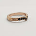 Side view of engraved 14k rose gold chevron ring with black spinels and millgrain edge