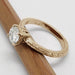 Side view of engraved 14k yellow gold moissanite engagement ring on pencil