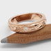 Engraved 14kt rose gold wedding ring with Canadian diamonds, resting on a pencil