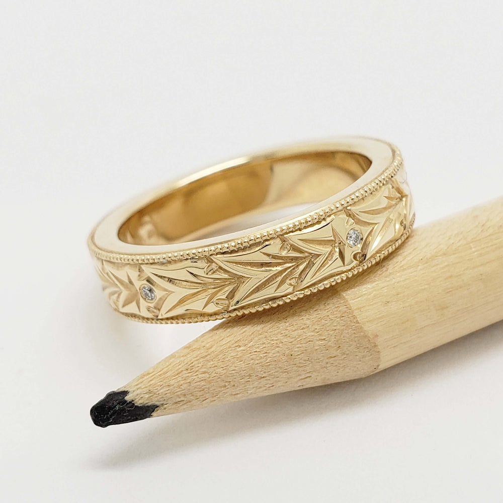 Engraved 14kt yellow gold wedding ring with Canadian diamonds, beside pencil