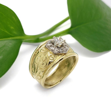 Engraved 18kt yellow gold vintage ring with white gold setting and diamond halo near a green leaf