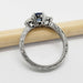 Engraved white gold band with three-stone sapphire and diamond setting, side view