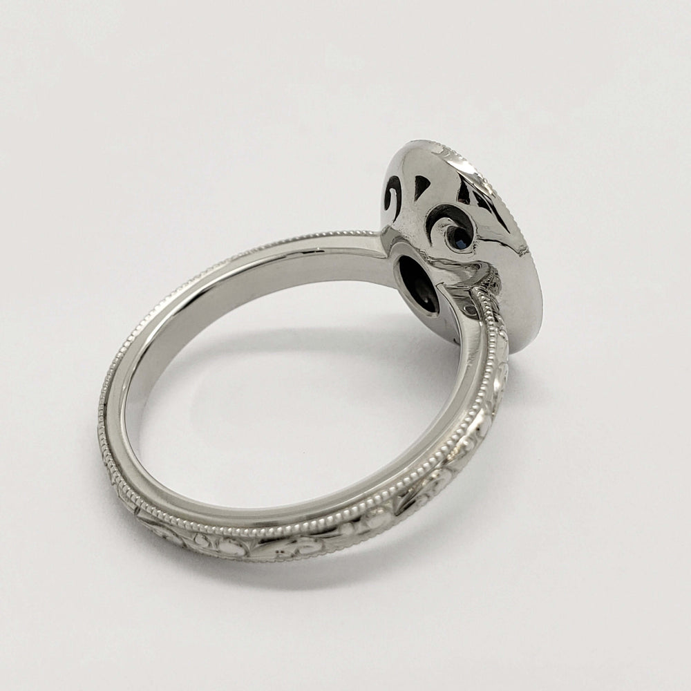 Side view of engraved white gold ring with detailed under-gallery and milgrain edges