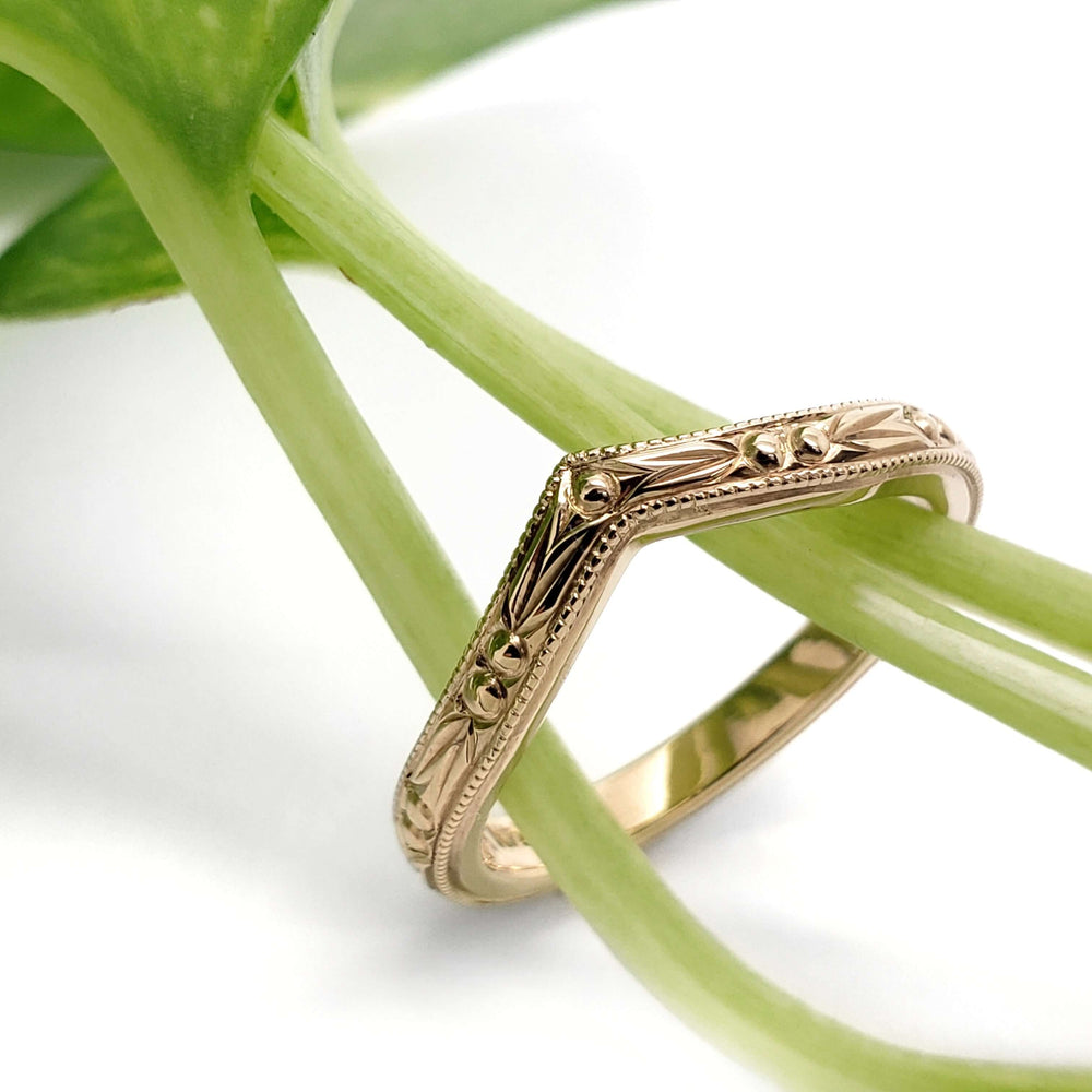 Engraved 14kt yellow gold chevron wedding ring styled with green plant stems
