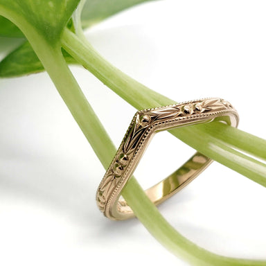 Engraved 14kt yellow gold chevron wedding ring styled with green plant stems