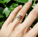 Engraved yellow gold wedding band stacked with a pear-shaped gemstone ring