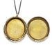 An open round gold-toned locket pendant necklace on a black cord, photographed against a plain white background.