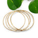 Five hammered 14kt yellow gold bangles arranged with green leaves