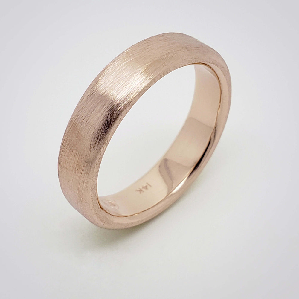 Flat 14k rose gold wedding ring with brushed surface on white background