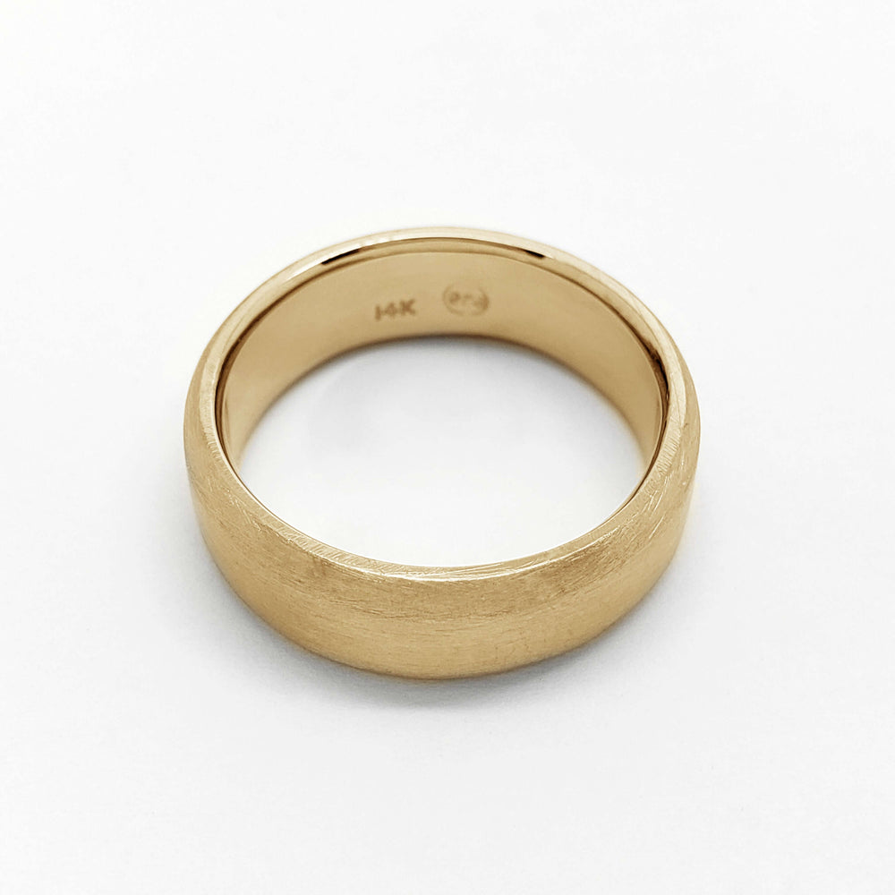 Flat 14k yellow gold wedding ring with brushed texture, viewed from above
