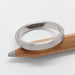 Flat brushed 14k white gold wedding ring resting on a wooden pencil