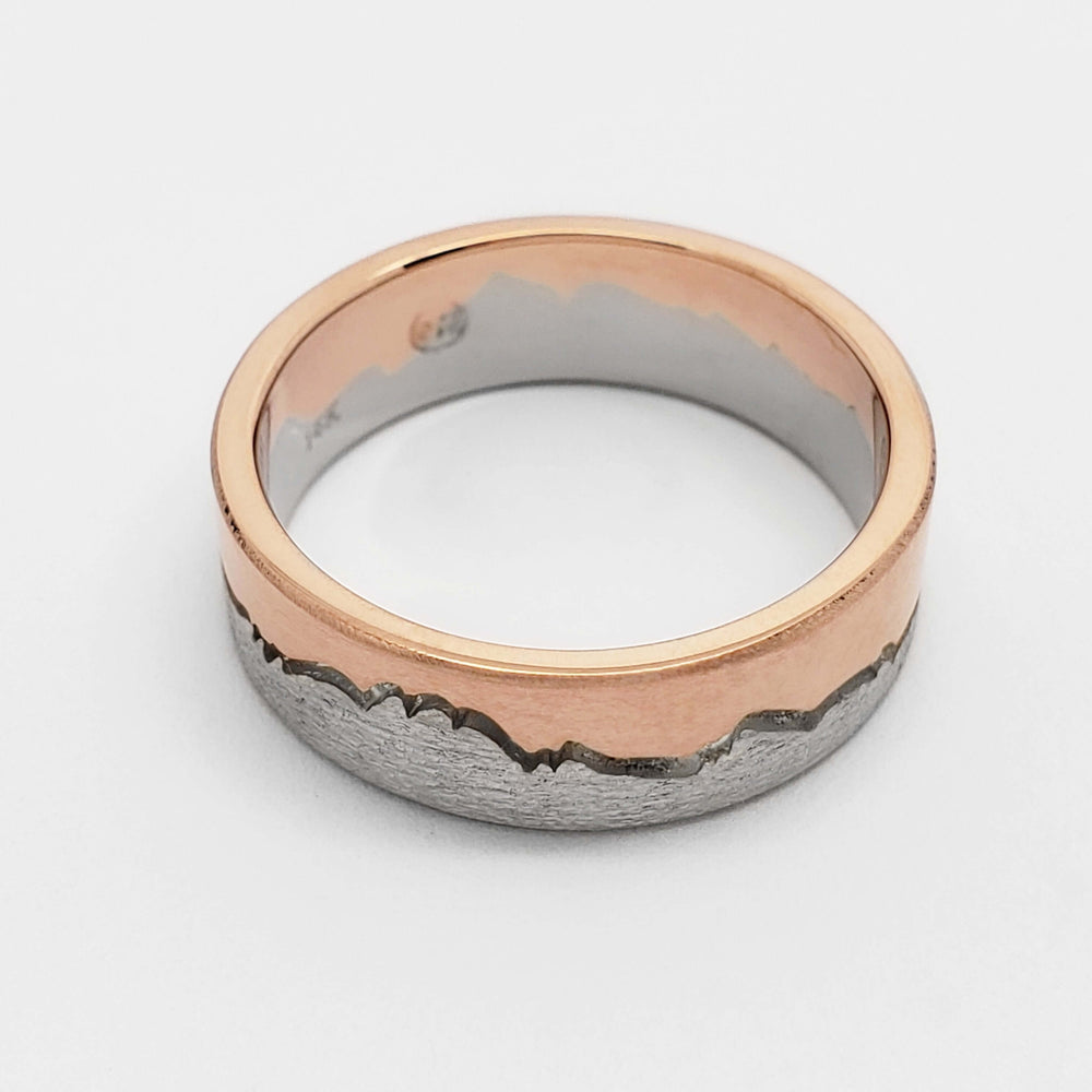 Flat profile 14k white and rose gold mountain range wedding ring on white background