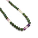 Close-up of green serpentine round beads and purple-green fluorite tube beads on a necklace