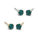 Four lab emerald stud earrings in 14kt yellow and white gold on a white background