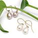 Freshwater pearl dangle earrings in mauve and white on 14kt yellow gold hooks, styled with green leaves
