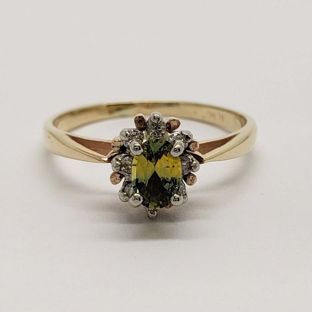 Front view of 10kt yellow gold ring with oval green sapphire and diamond halo