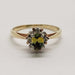 Front view of 10kt yellow gold ring with oval green sapphire and diamond halo