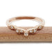Front view of 14k rose gold wedding ring with bezel and pave-set Canadian diamonds
