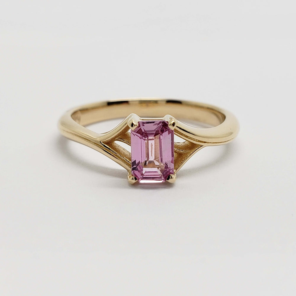 Front view of 14k yellow gold ring with emerald cut pink sapphire