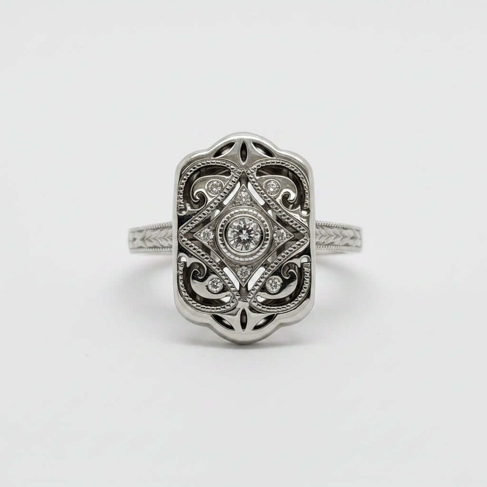 Front view of 14kt white gold and diamond Edwardian engagement ring with intricate engraving